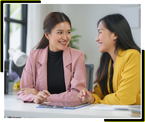 Zwei Frauen besprechen CRM-Strategien mit Greyhound auf einem Tablet